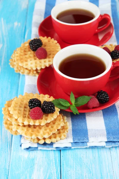 Tazas de té con galletas y bayas en primer plano de la mesa — Foto de Stock