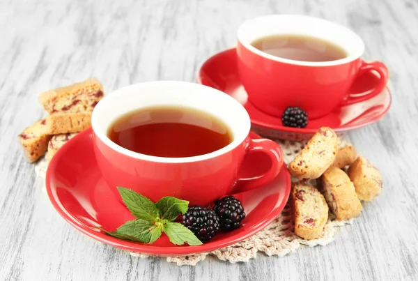Cups of tea with cookies and blackberry on table close-up — Stock Photo, Image