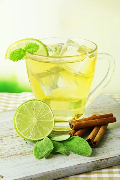 Taza transparente de té verde hielo en la mesa sobre fondo brillante —  Fotos de Stock