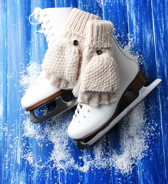 Wool fingerless gloves and skates for figure skating, on wooden background — Stock Photo, Image