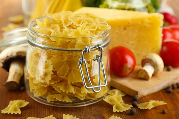 Pasta with oil, cheese and vegetables on wooden table close-up — Stock Photo, Image