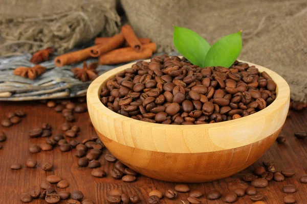 Grains de café dans un bol sur fond en bois — Photo