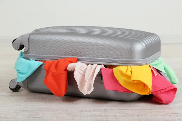 Suitcase with clothes on floor — Stock Photo, Image