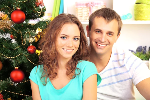 Happy young couple near Christmas tree at home — Stock Photo, Image