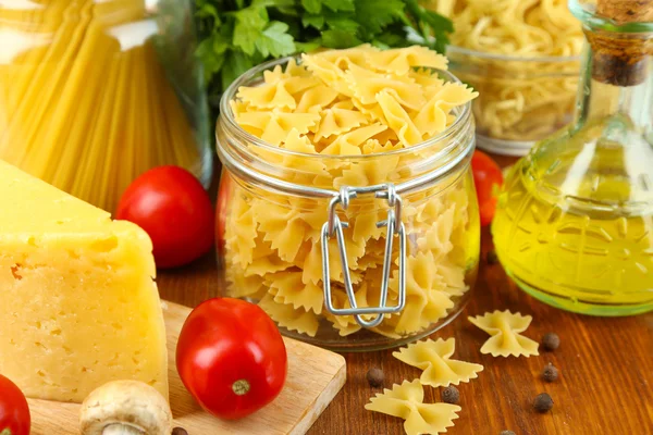 Pâtes à l'huile, fromage et légumes sur table en bois close-up — Photo