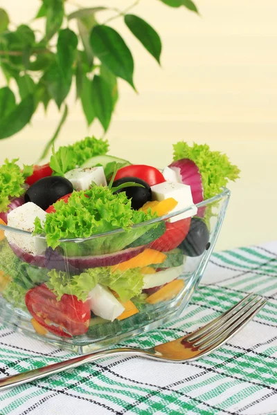 Salad Yunani di piring di atas meja pada latar belakang cahaya — Stok Foto