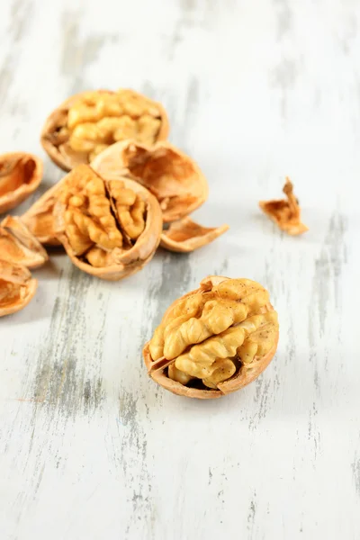 Broken walnuts on wooden table close-up — Stock Photo, Image