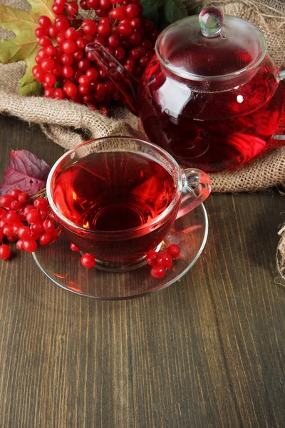 Bodegón con té de viburnum en servilleta de tela de saco, sobre fondo de madera — Stok fotoğraf