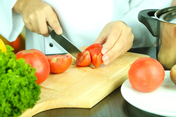 Mãos de cozinheiro corte de tomate — Fotografia de Stock