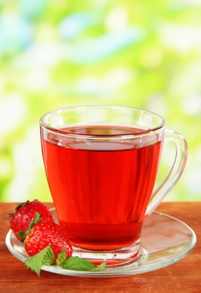 Delicioso té de fresa en la mesa sobre fondo brillante — Foto de Stock