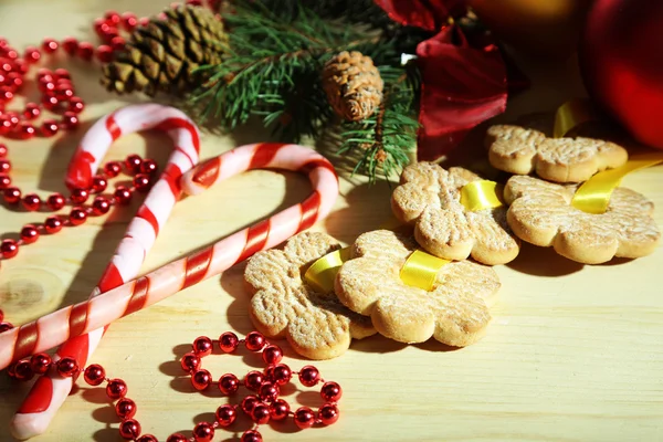 Biscoitos em fitas com decorações de Natal em mesa de madeira — Fotografia de Stock