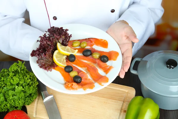 Cocinar las manos sosteniendo plato en el lugar de trabajo —  Fotos de Stock