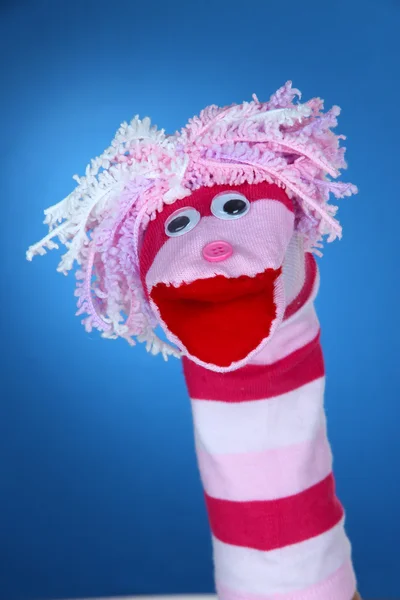 Cute sock puppet on blue background — Stock Photo, Image