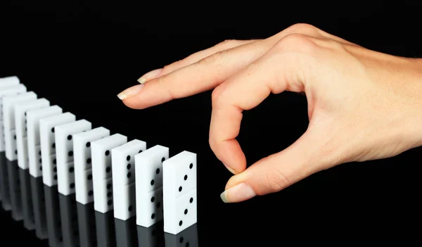 Hand pushing dominoes isolated on black — Stock Photo, Image