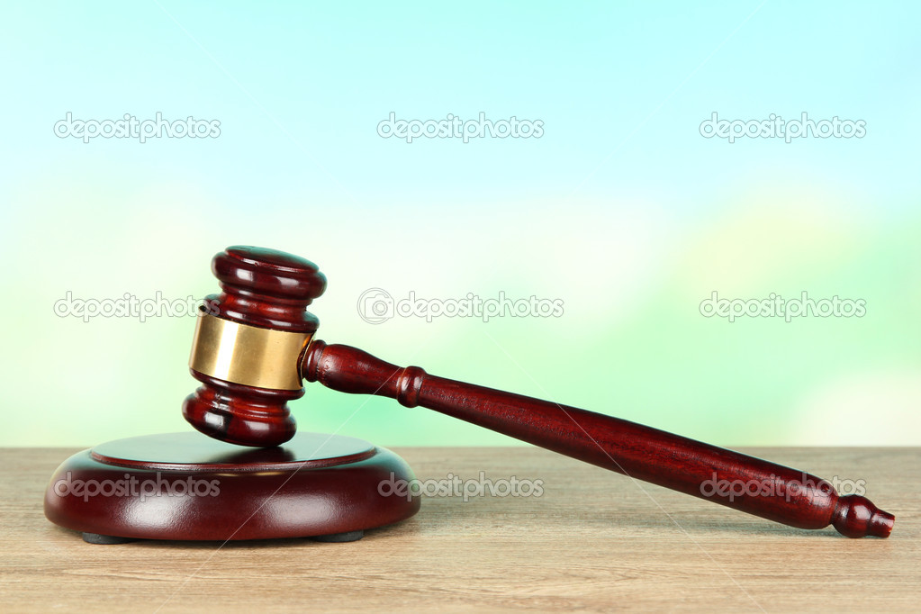 Judges gavel on wooden table on light background