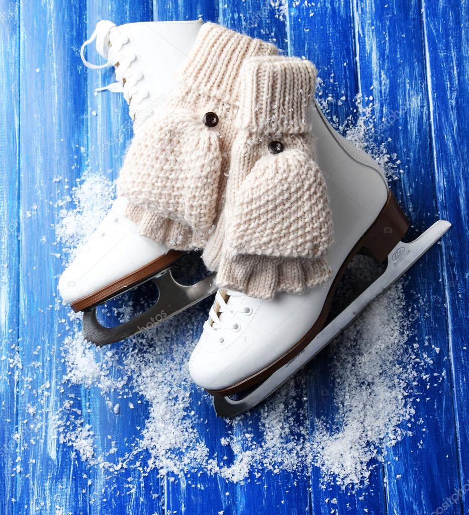 Wool fingerless gloves and skates for figure skating, on wooden background