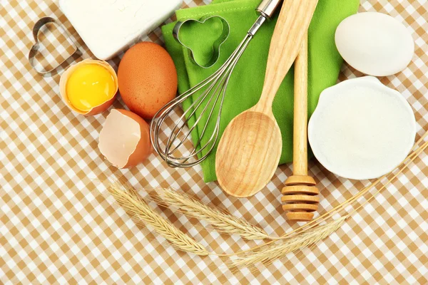 Conceito de cozinha. Ingredientes básicos de cozimento e ferramentas de cozinha em fundo de toalha de mesa — Fotografia de Stock