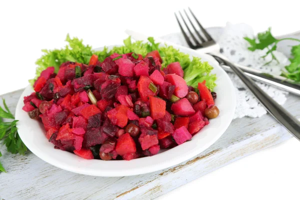 Beet salad on plate on napkin on wooden board isolated on white — Stock Photo, Image