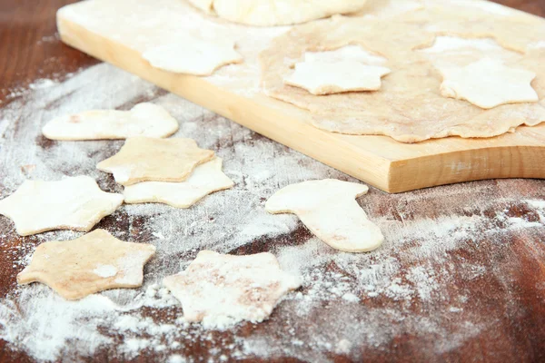 Massa de farinha de biscoitos de Natal em tábua de madeira na mesa — Fotografia de Stock