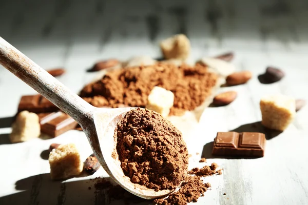 Poudre de cacao dans une cuillère sur une table en bois — Photo