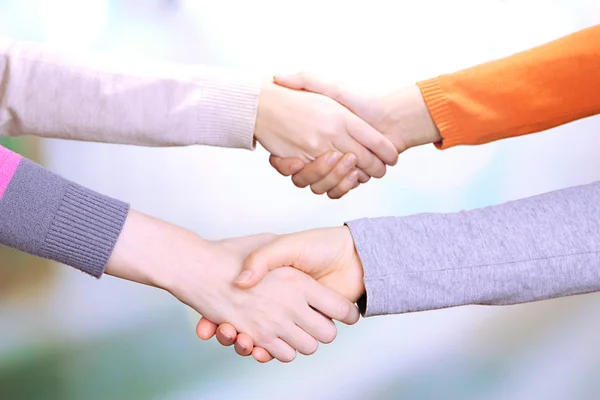Handshakes on bright background — Stock Photo, Image