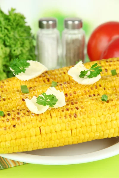 Delicioso maíz dorado a la parrilla con mantequilla en la mesa sobre fondo brillante — Foto de Stock
