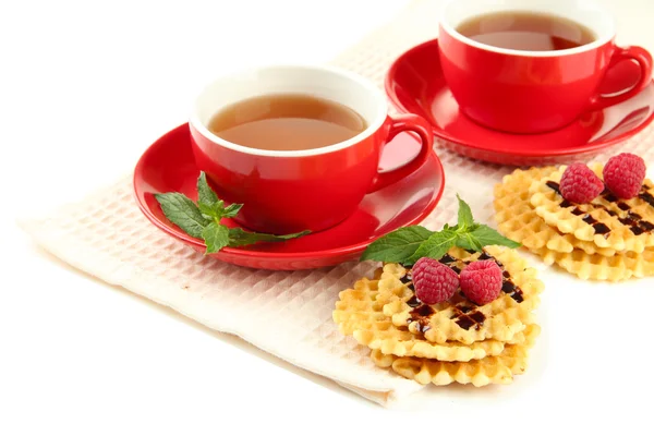 Kopjes thee met koekjes en frambozen geïsoleerd op wit — Stockfoto