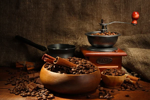 Coffee grinder, turk and cup of coffee on burlap background — Stock Photo, Image