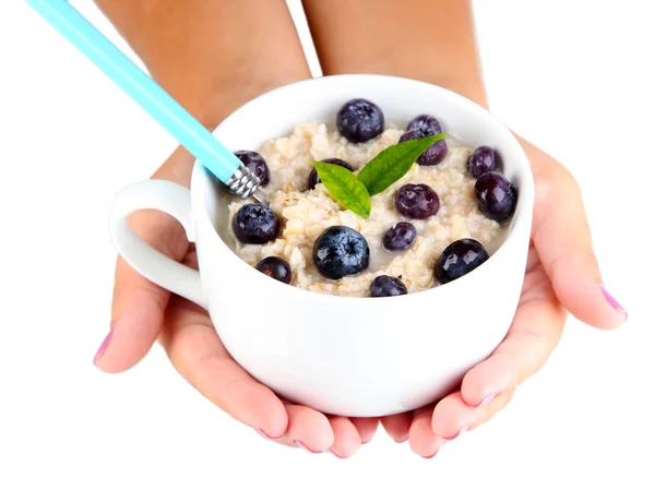 Harina de avena en taza con bayas en las manos aisladas en blanco — Foto de Stock