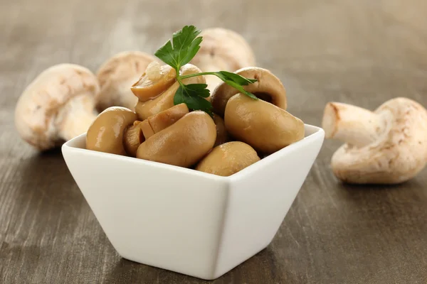 Delicious marinated mushrooms in bowl on wooden table close-up — Stock Photo, Image