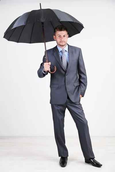 Geschäftsmann mit Regenschirm. auf grauem Hintergrund — Stockfoto