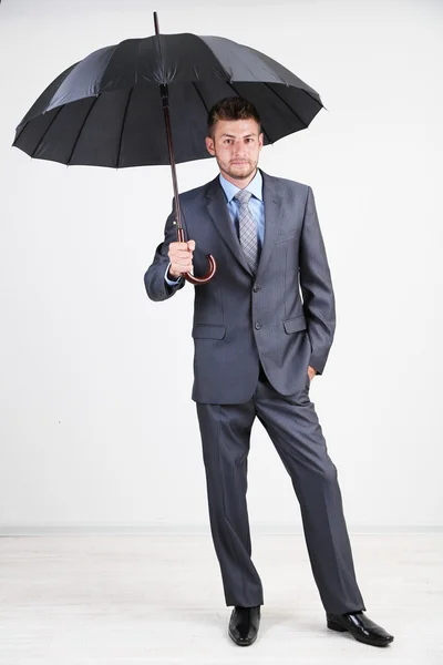 Businessman with umbrella. on gray background Royalty Free Stock Images