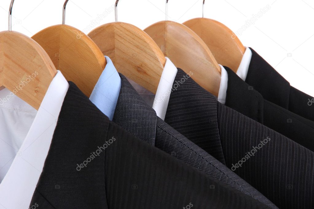 Suits with shirts on hangers on white background