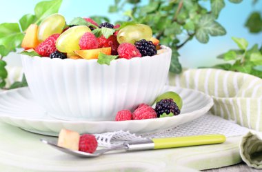 parlak zemin üzerine ahşap masa üzerinde kase meyve salatası