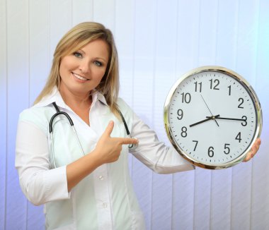 genç güzel doktor stetoskop ve saati, açık renkli