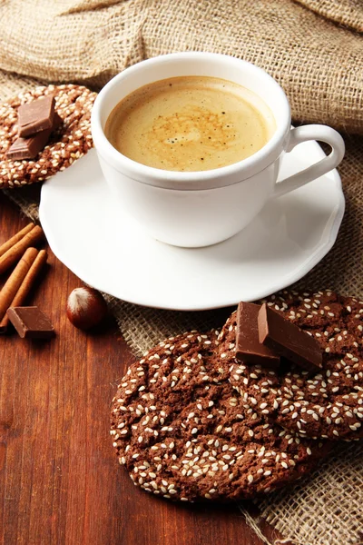 Cup of tasty coffee with tasty cookies, on wooden background — Stock Photo, Image