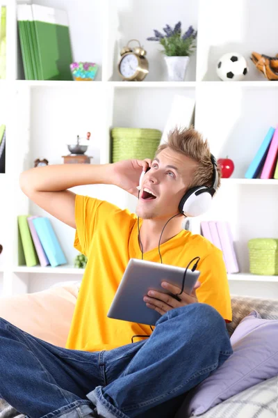 Hombre joven relajándose en el sofá con la tableta — Foto de Stock