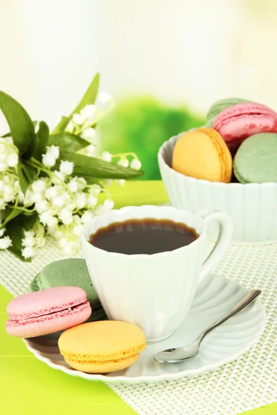 Café y macarrones sobre mesa sobre fondo claro —  Fotos de Stock