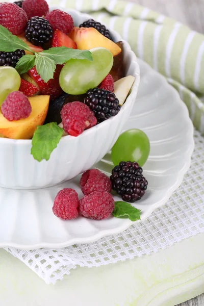 Salade de fruits dans un bol, sur fond de bois — Photo