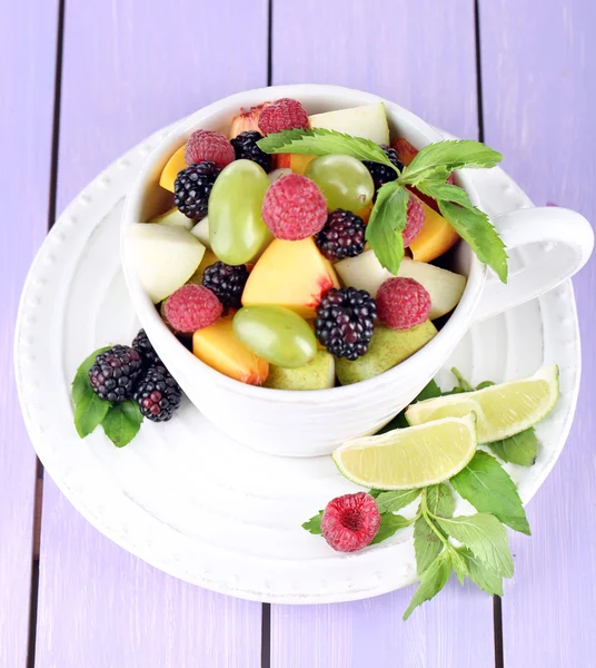 Obstsalat in Tasse auf Holztisch — Stockfoto