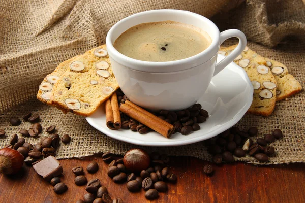 Taza de sabroso café con sabrosas galletas italianas, sobre fondo de madera —  Fotos de Stock