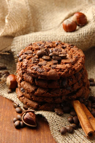 Homemade cookies with sesame seeds, chocolate, on wooden table, on sackcloth background — Stock Photo, Image