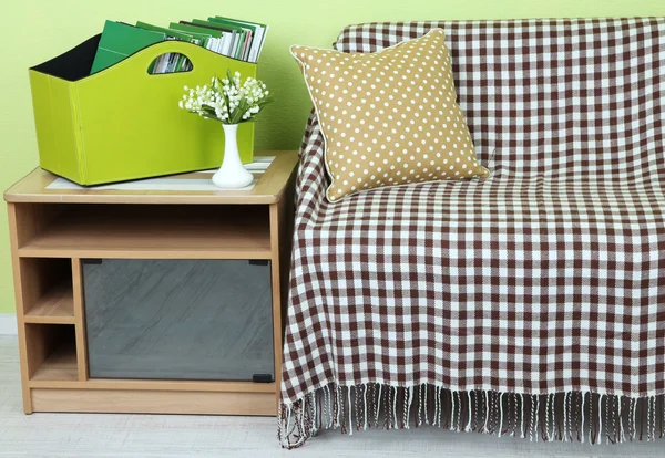 Magazines and folders in green box on bedside table in room — Stock Photo, Image