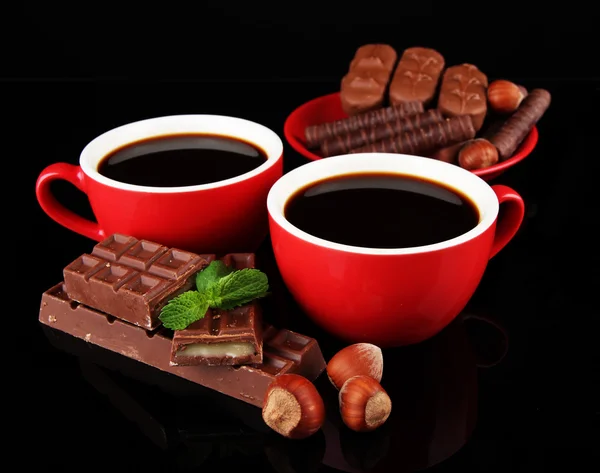 Tazze rosse di caffè forte e barrette di cioccolato isolate su nero — Foto Stock