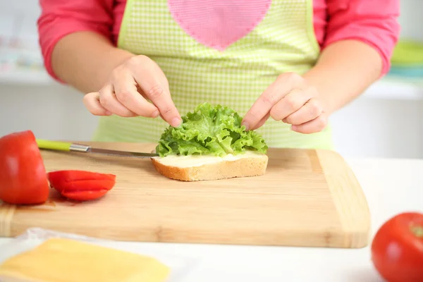 Happy smiling woman in kitchen preparing sandwich, close up — Stock Photo, Image