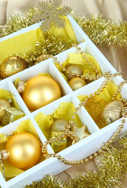 Vánoční hračky v dřevěné krabici na světlé pozadí — Stock fotografie