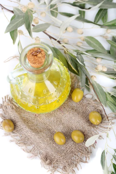 El aceite de oliva y la rama en tela de saco de cerca —  Fotos de Stock