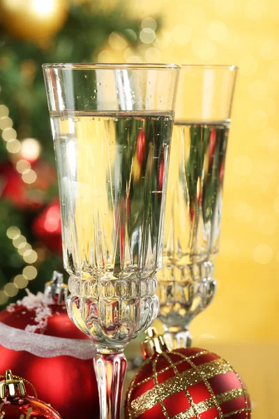 Kompozycja z ozdób choinkowych i dwa kieliszki do szampana, na jasnym tle — Zdjęcie stockowe
