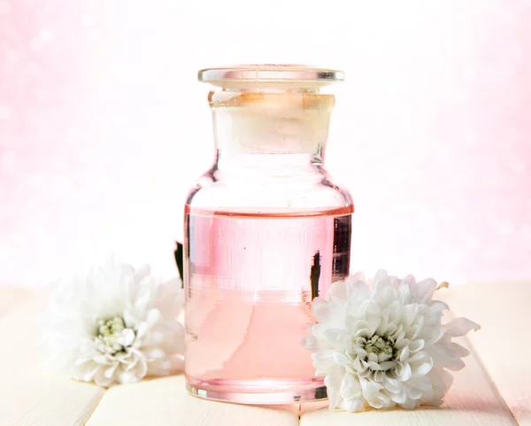 Glass bottle with color essence, on pink background — Stock Photo, Image