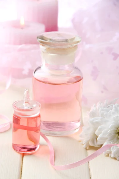 Glass bottle with color essence, on wooden background — Stock Photo, Image